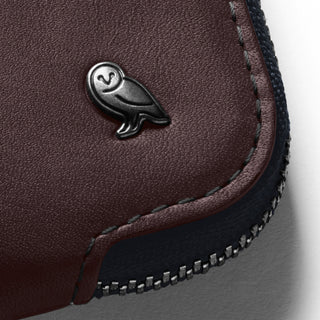 Bellroy Card Pocket close-up showing brown leather texture and owl logo detail with stitched edging and zipper