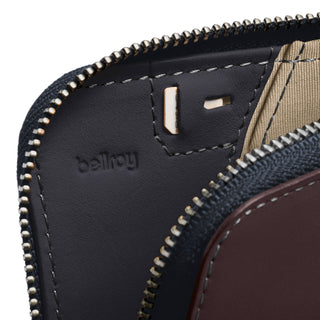 Bellroy Card Pocket showing black leather interior detail with embossed logo and metal zipper close-up