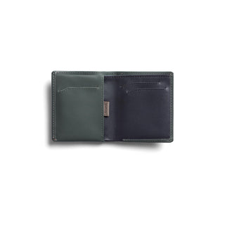 Bellroy Note Sleeve wallet open showing dark green and black leather card slots with smooth texture