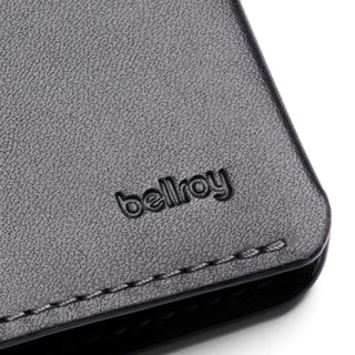 Close-up of textured black leather on Bellroy Passport Cover with visible stitching and embossed logo detail
