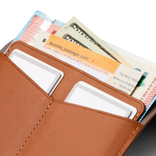 Bellroy Passport Cover in tan leather holding cards, currency, and travel documents with fine stitching detail