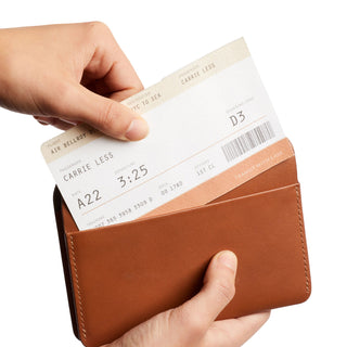 Bellroy Passport Cover in brown leather held open with a boarding pass partially inserted
