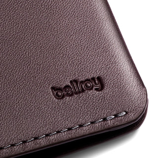 Close-up of dark brown leather detail with embossed Bellroy logo on the Bellroy Passport Cover corner