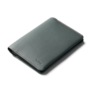 Bellroy Passport Cover in dark green leather with detailed stitching shown at an angled view