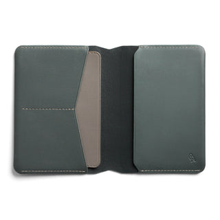 Bellroy Passport Cover in muted green leather opened showing card and passport slots with stitching detail