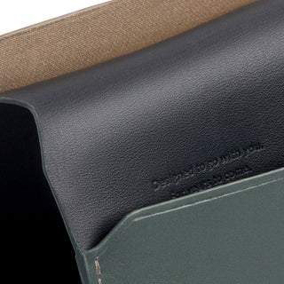Bellroy Passport Cover showing smooth black leather interior and olive green textured exterior close-up