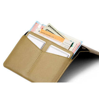 Bellroy Passport Cover open showing tan leather interior with cards and currency inside slots