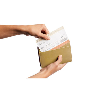 Bellroy Passport Cover in olive leather held open showing boarding pass inside