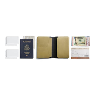 Bellroy Passport Cover in tan leather displayed open with passport, cards, and cash nearby