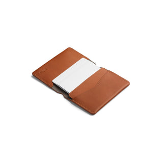Bellroy Under Cover tan leather card holder open with white cards inside on white background