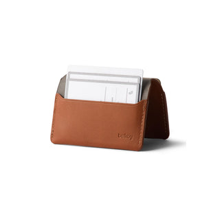 Bellroy Under Cover tan leather card holder with slim profile and visible white cards inside pocket