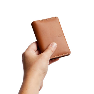 Bellroy Under Cover tan leather card holder held in hand showing smooth texture and stitching details