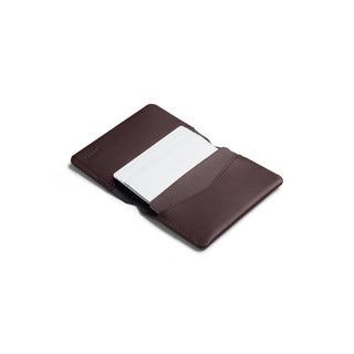 Bellroy Under Cover card holder in rich brown leather with white card partially inserted open flat