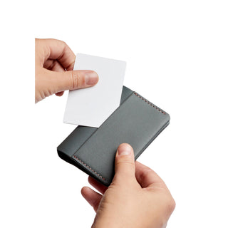 Bellroy Under Cover card holder in gray leather held while inserting a white card