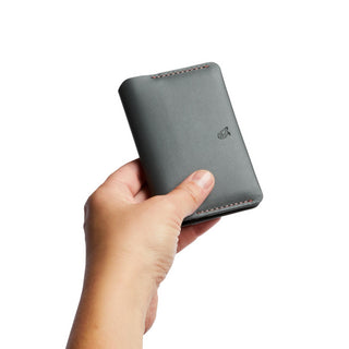 Bellroy Under Cover card holder in dark leather held by hand showing compact, smooth finish and stitched edges