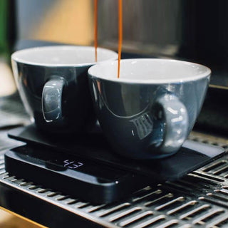 ACAIA Lunar Portafilter Weighing Plate holding two gray cups with espresso dripping into them