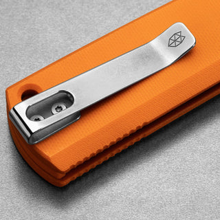Close-up on silver clip detail of orange Micarta handle James The Kline Knife by The James Brand