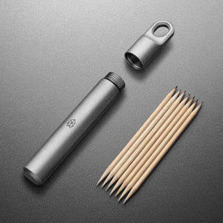 James The Randolph Capsule by The James Brand with titanium body and wooden toothpicks on gray surface