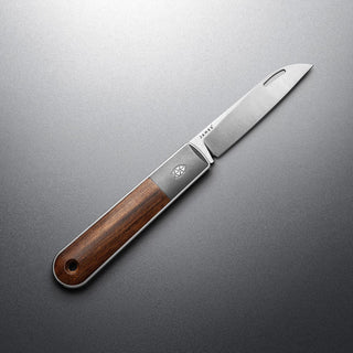 James The Wayland Knife with rosewood handle and stainless steel blade on gray surface