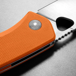 James The Folsom Knife with textured orange G10 handle and partially serrated VG-10 steel blade close-up