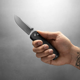 Hand holding James The Kline Knife with black Micarta handle and drop point CPM Magnacut blade