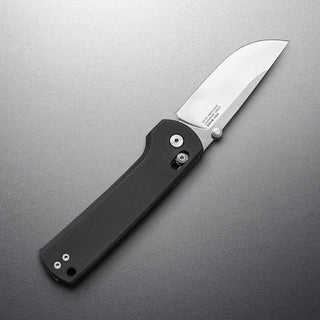 James The Kline Knife with textured black Micarta handle and polished drop point blade open on gray background