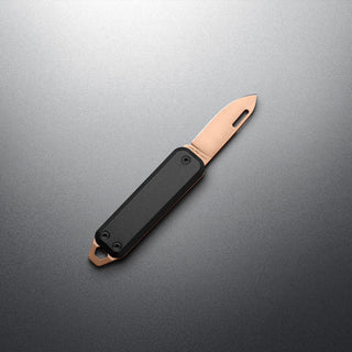 James The Elko Knife with black G10 handle and compact copper-toned blade on grey background