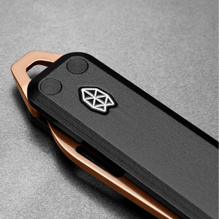 James The Elko Knife showing black Micarta handle with copper aluminum frame and emblem detail