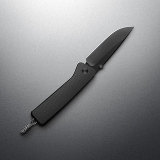 James The Barnes Knife with textured black handle and sleek dark stainless steel blade on gray surface