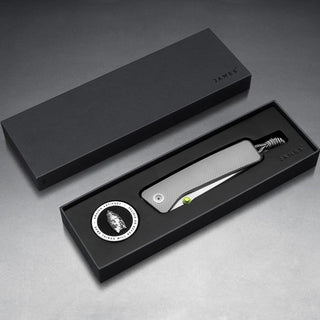 James The Barnes Knife with textured titanium handle displayed in sleek black packaging by The James Brand