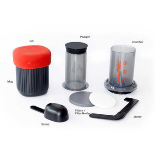 AeroPress Go Coffee Maker disassembled with red lid, black mug, clear chamber, plunger, scoop, and filter parts on white background