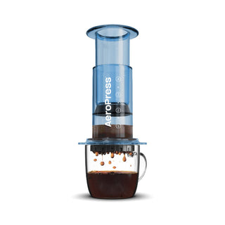 AeroPress Clear Coffee Maker brewing coffee directly into a transparent glass cup with dark coffee dripping