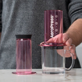 AeroPress Clear Coffee Maker with translucent purple plunger and clear sturdy brewing chamber on countertop