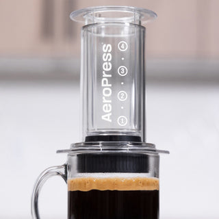 AeroPress Clear Coffee Maker brewing fresh coffee with clear plastic design and measurement markings