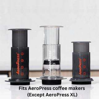 AeroPress Flow Control Filter Cap in black polypropylene shown with AeroPress coffee makers on white surface