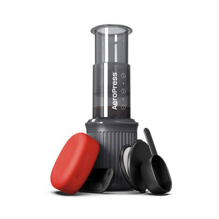 AeroPress Go Coffee Maker compact black brewing device with red travel case and scoops on white background