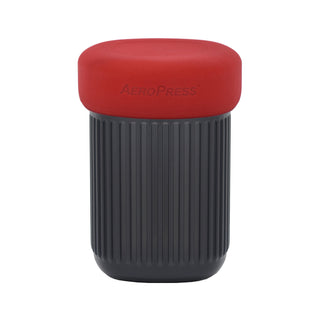 AeroPress Go Coffee Maker with ribbed black body and smooth red lid featuring embossed logo