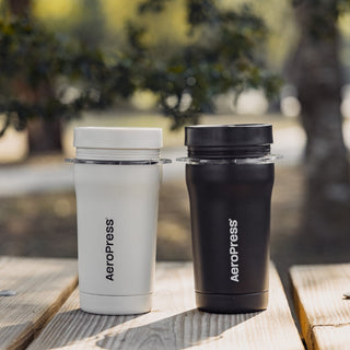 AeroPress Go Plus Travel System showing black and white durable stainless steel coffee makers outdoors
