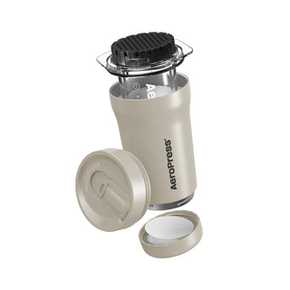 AeroPress Go Plus Travel System with beige cup, black filter cap, and compact lid for coffee brewing