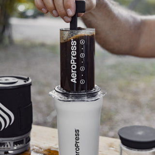 AeroPress Go Plus Travel System brewing fresh coffee with clear measurement markings and sturdy plunger hand use