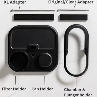 AeroPress Organizer with black plastic holders for filter, cap, chamber, plunger, and metal adapters displayed flat