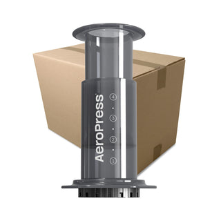 AeroPress Original Coffee Maker with translucent black body and measurement markings against cardboard box background