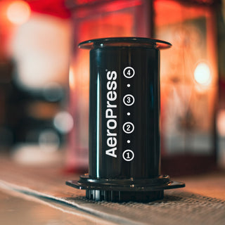 AeroPress Original Coffee Maker black cylindrical plunger with volume markings on wooden surface