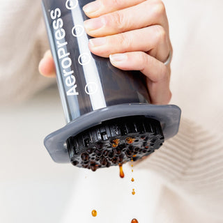 AeroPress Original Coffee Maker in use with coffee dripping through durable black filter cap
