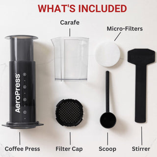 AeroPress XL Coffee Press set showing black press, clear carafe, scoop, stirrer, filter cap, and micro-filters on white surface