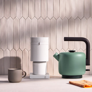 Fellow Clyde Electric Kettle (120V) (1500ml/50oz) in matte green with black handle on kitchen counter