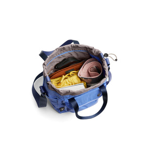 Bellroy Cinch Bucket Bag in blue showing organized interior with various personal items inside