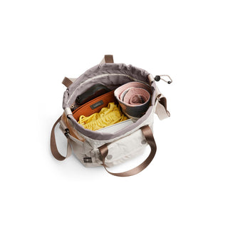 Bellroy Cinch Bucket Bag in light fabric showing spacious interior with organized personal items inside