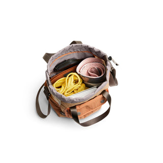 Bellroy Cinch Bucket Bag open showing organized interior with fabric items and adjustable shoulder strap