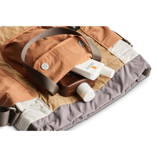 Bellroy Cinch Bucket Bag in tan with gray trim showing front pocket and strap details
